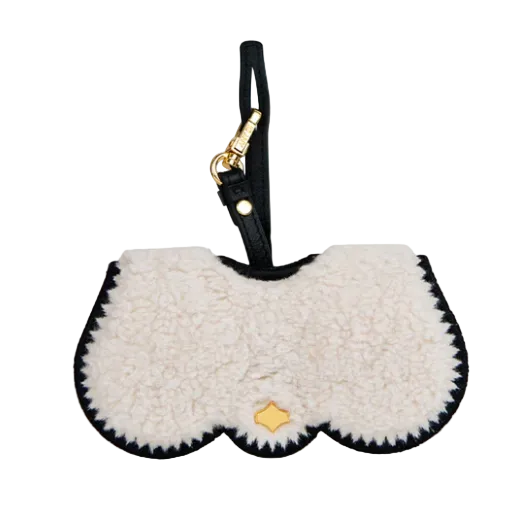 White fluffy pouch with black trim and gold tag on a white background