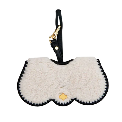 White fluffy pouch with black trim and gold tag on a white background