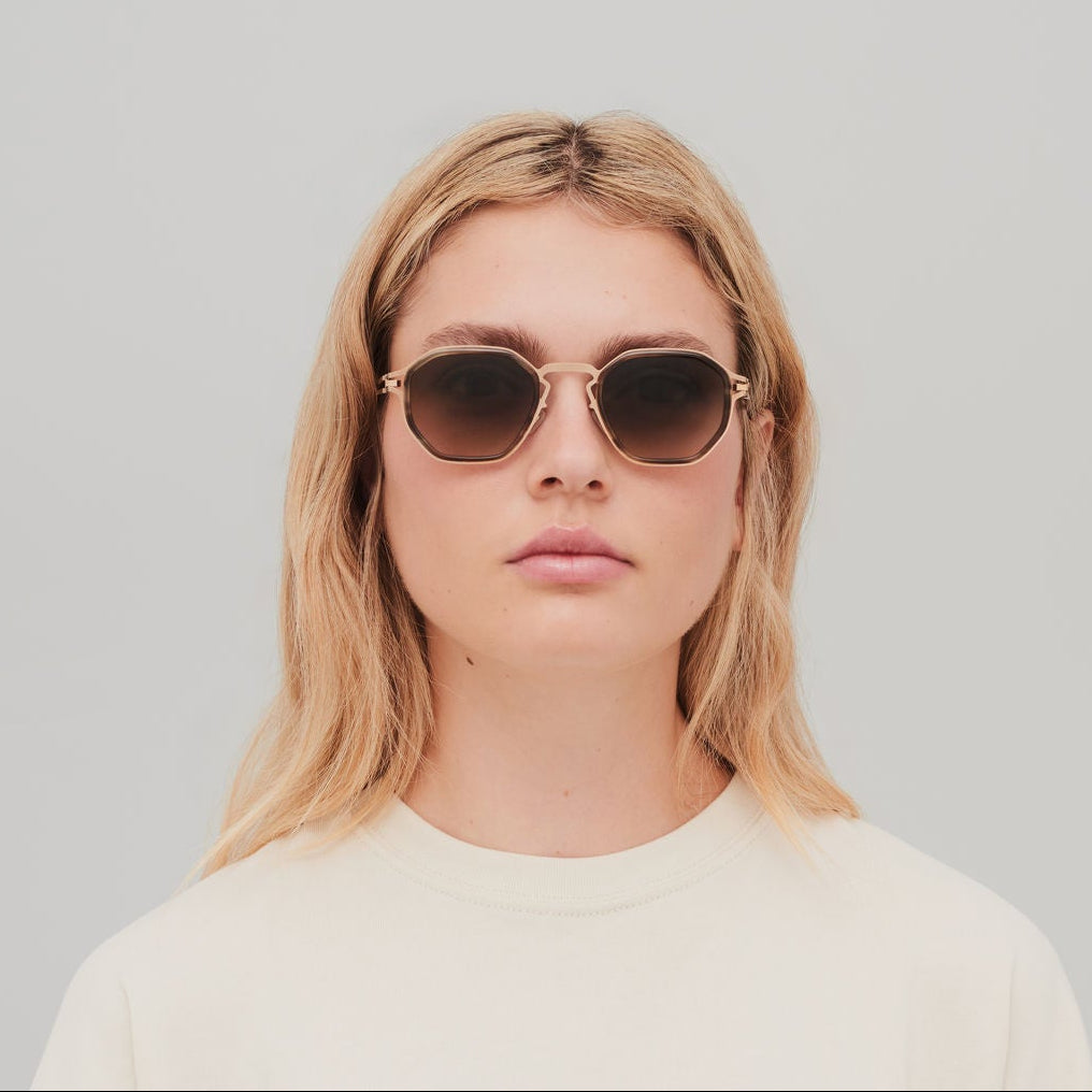 Person wearing sunglasses with a plain background